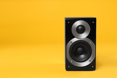Modern powerful audio speaker on yellow background, space for text