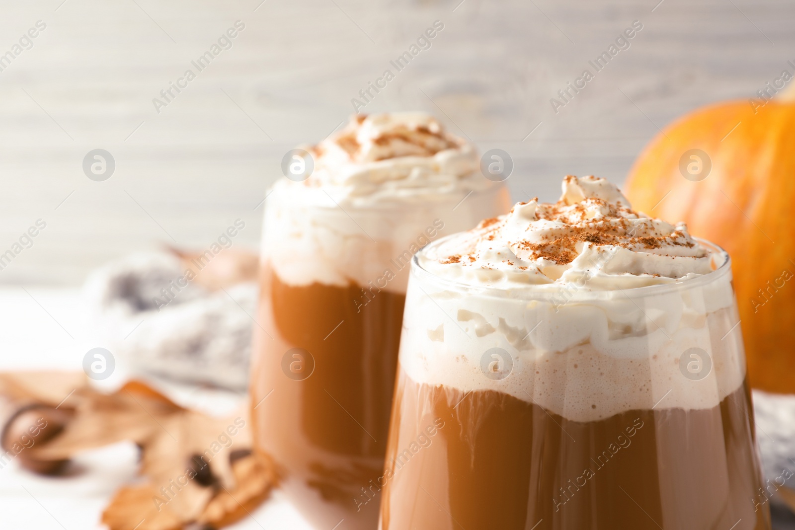 Photo of Glass with tasty pumpkin spice latte on table, closeup