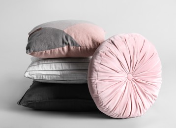 Different stylish soft pillows on grey background