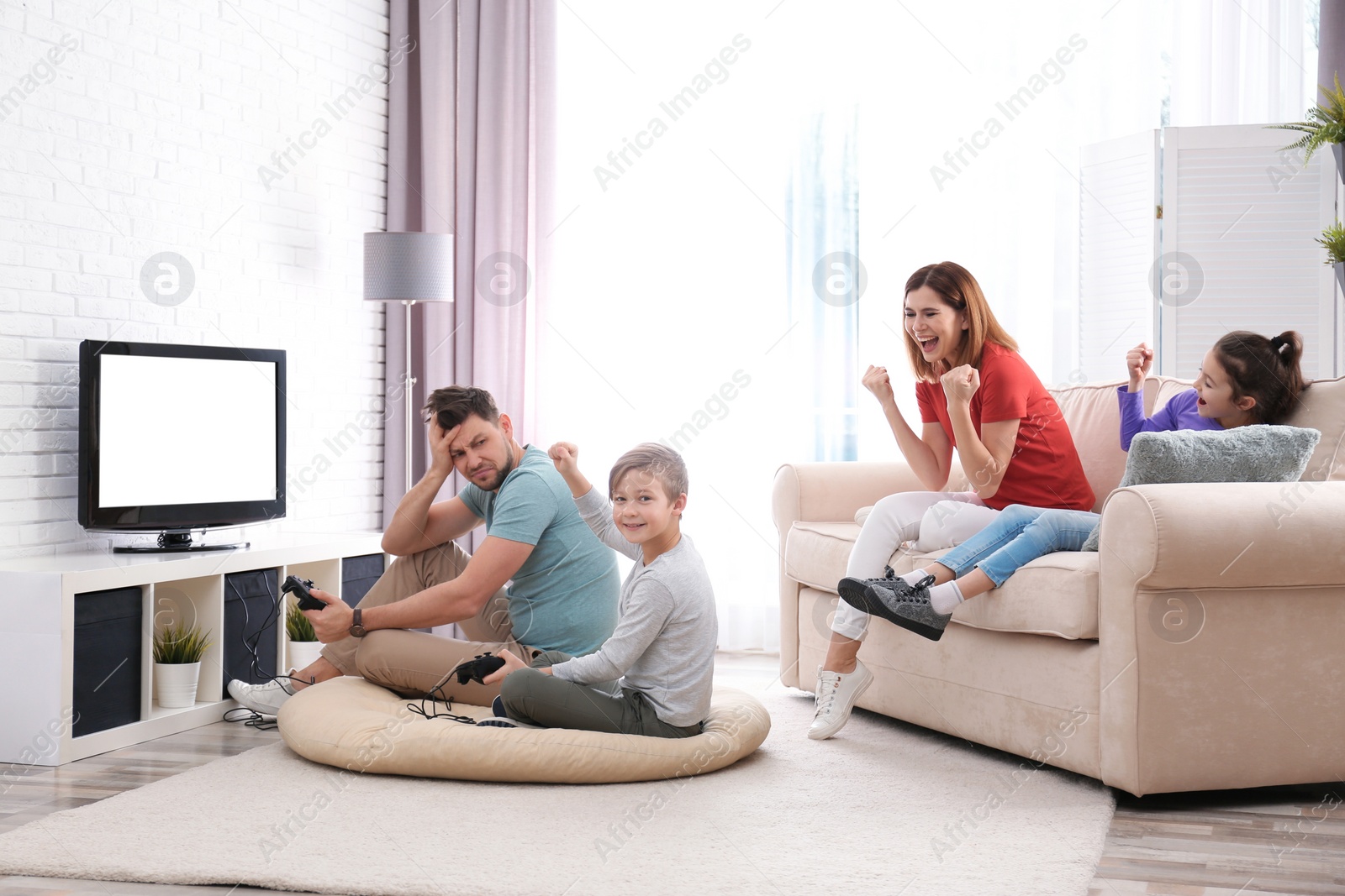 Photo of Happy family playing video games in living room