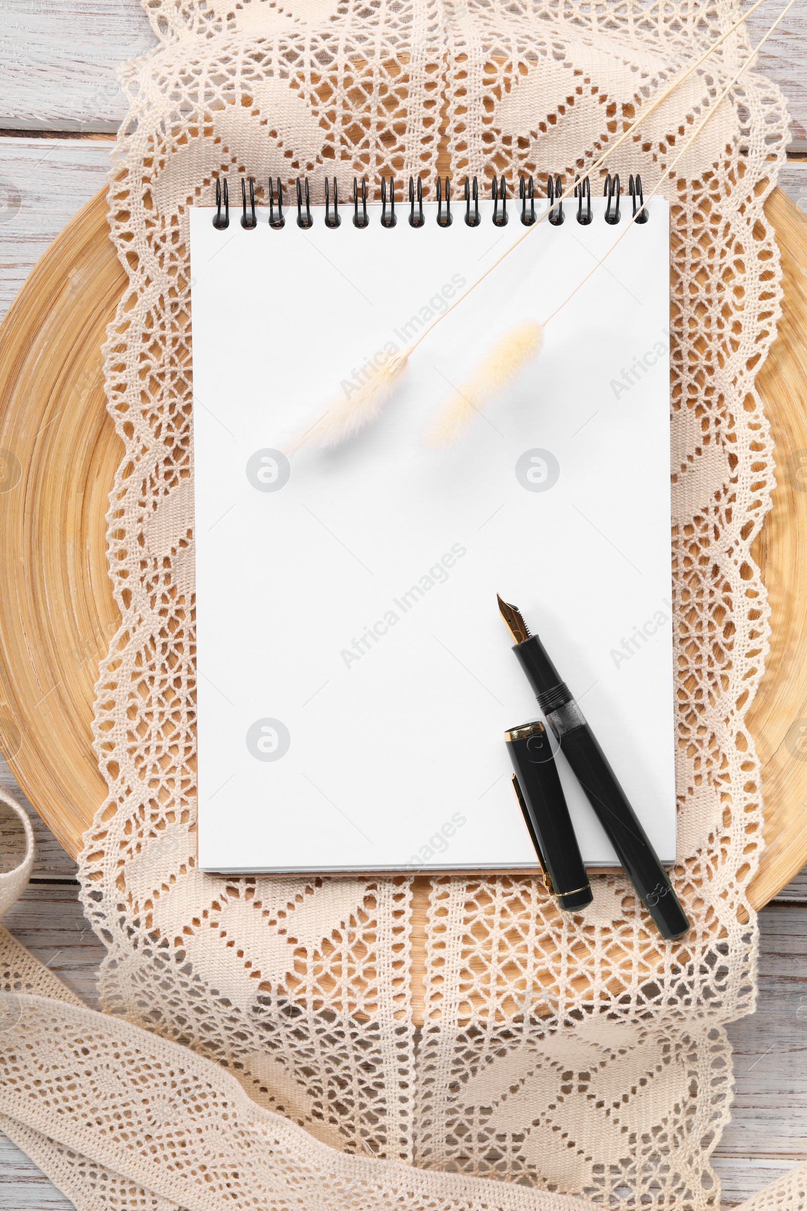 Photo of Guest list. Notebook, pen, spikelets and lace ribbons on wooden background, flat lay