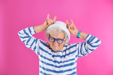 Photo of Portrait of cool grandmother on color background