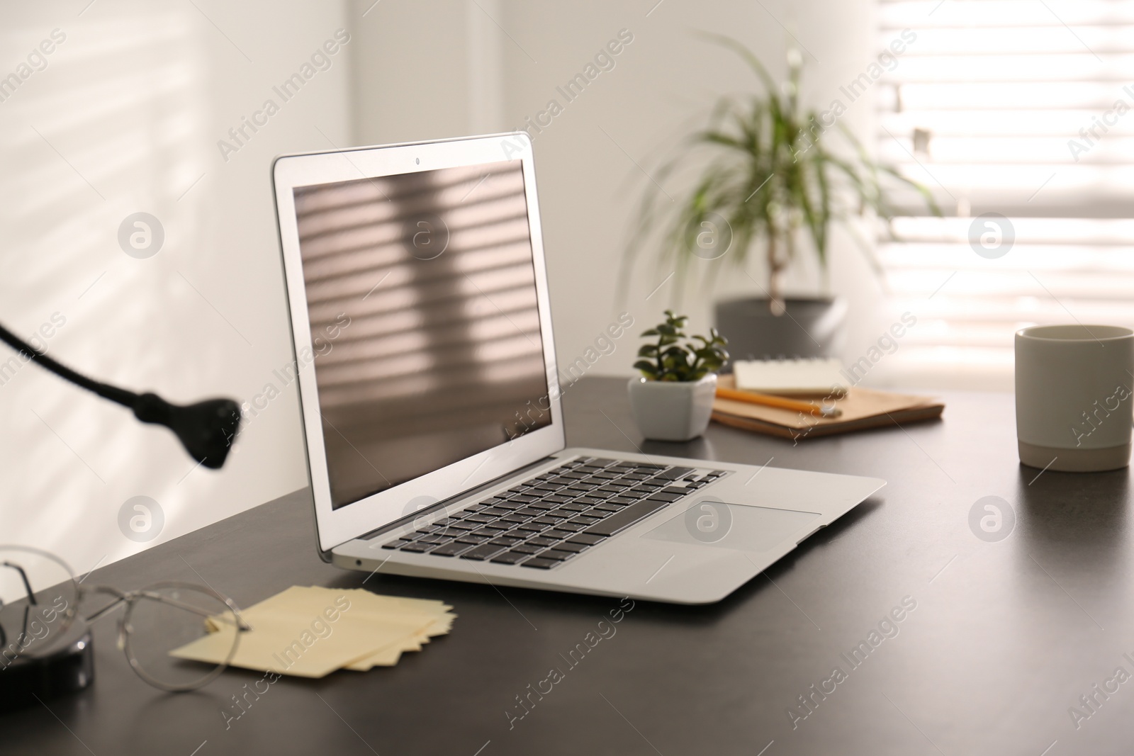 Photo of Modern laptop on office table. Stylish workplace