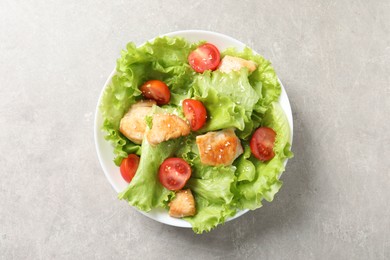 Delicious salad with chicken and cherry tomato on light grey table, top view