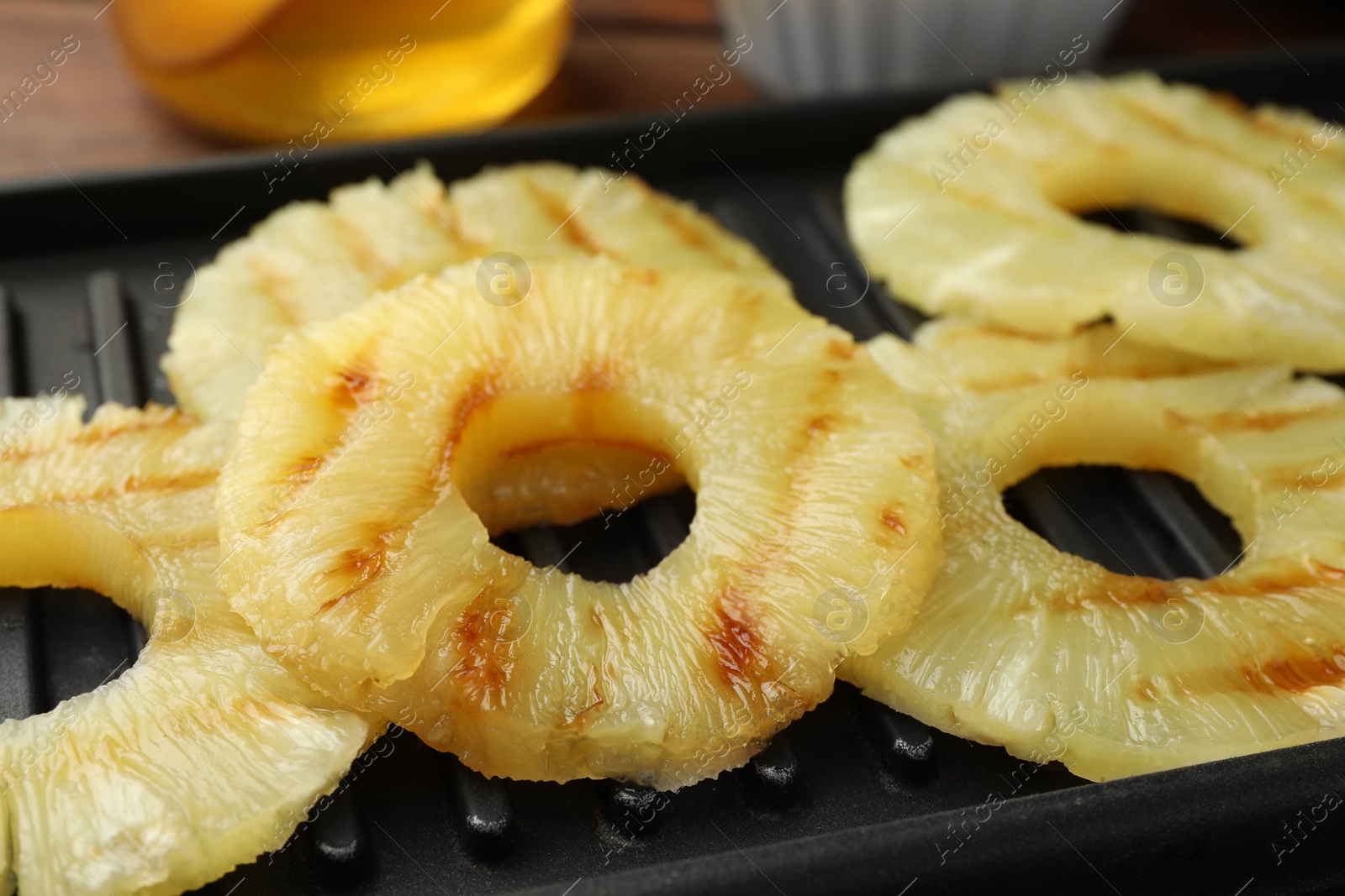 Photo of Tasty grilled pineapple slices on table, closeup