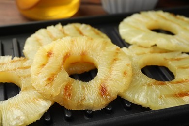 Tasty grilled pineapple slices on table, closeup