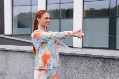 Photo of Beautiful woman in gym clothes doing exercises on street