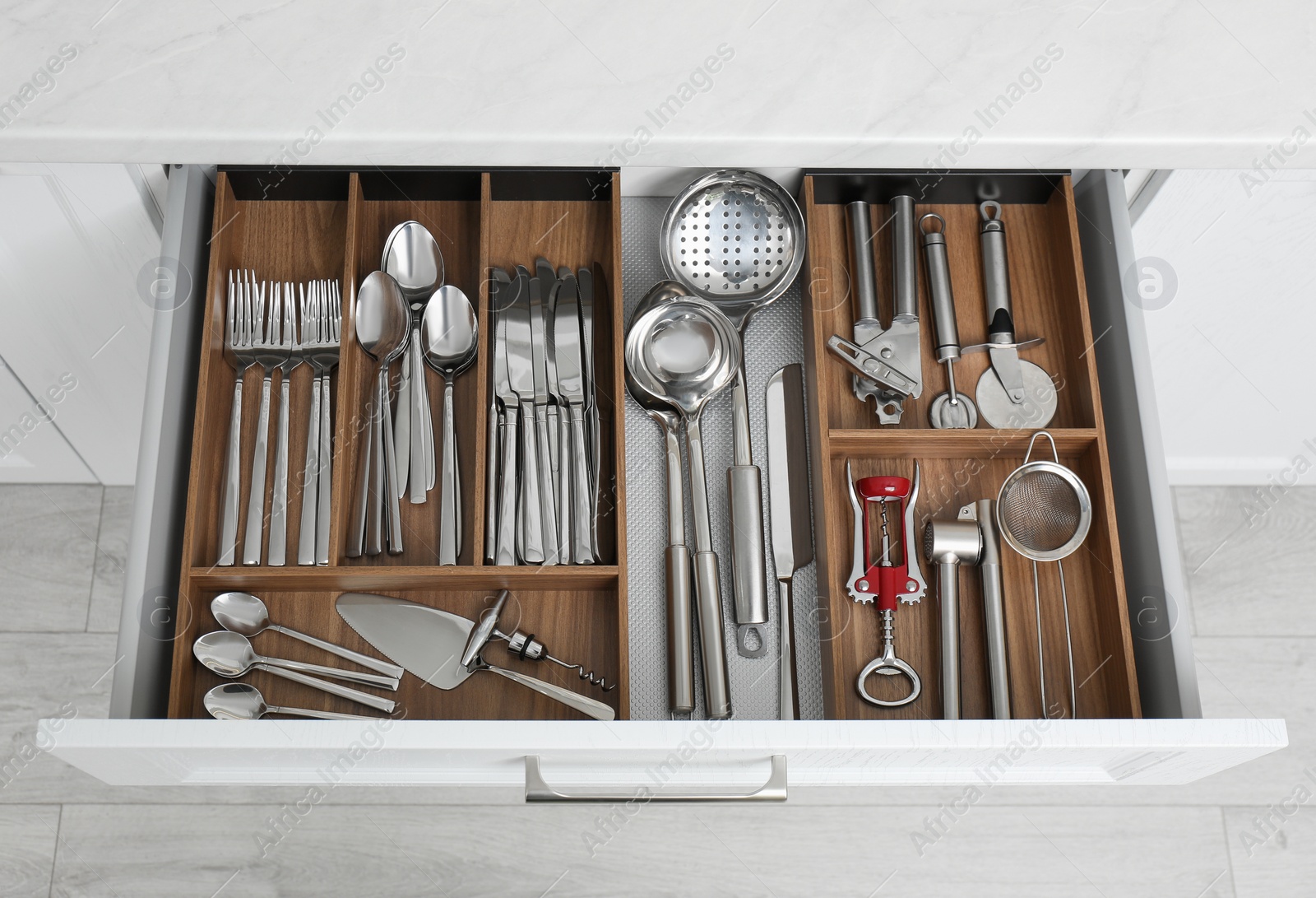 Photo of Open drawer with different utensils and cutlery in kitchen, above view