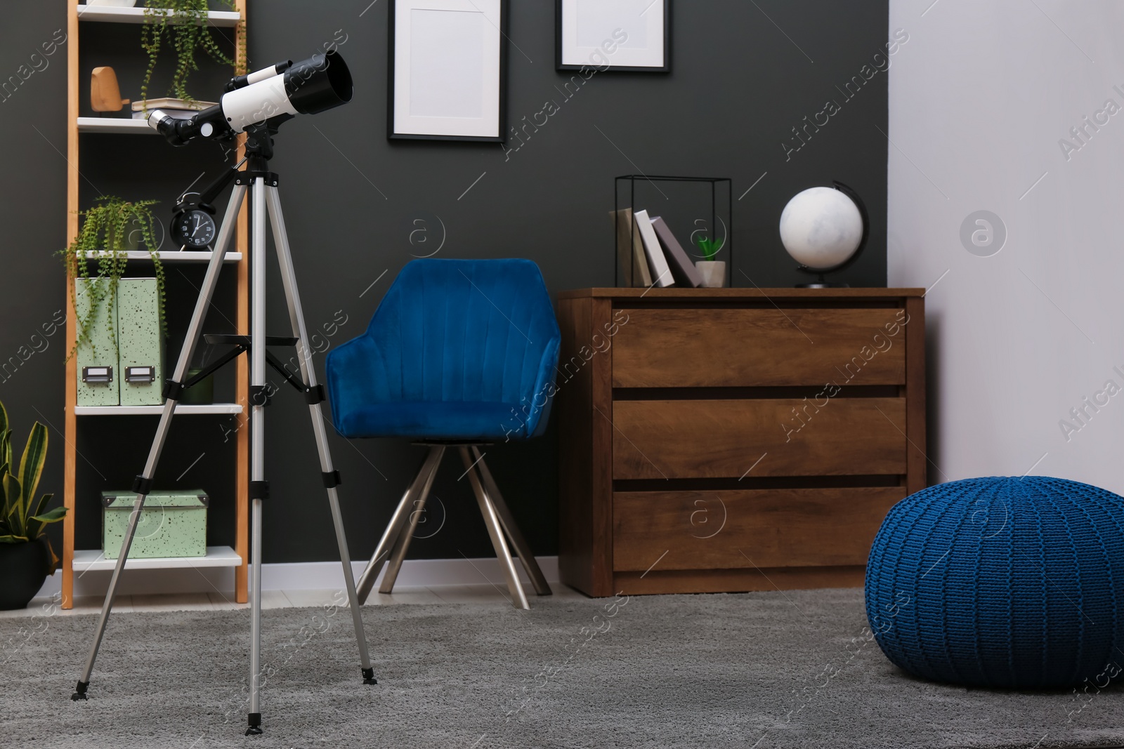 Photo of Tripod with modern telescope in stylish room