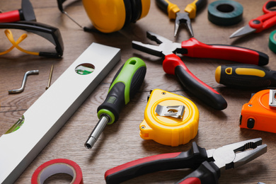 Different modern construction tools on wooden background