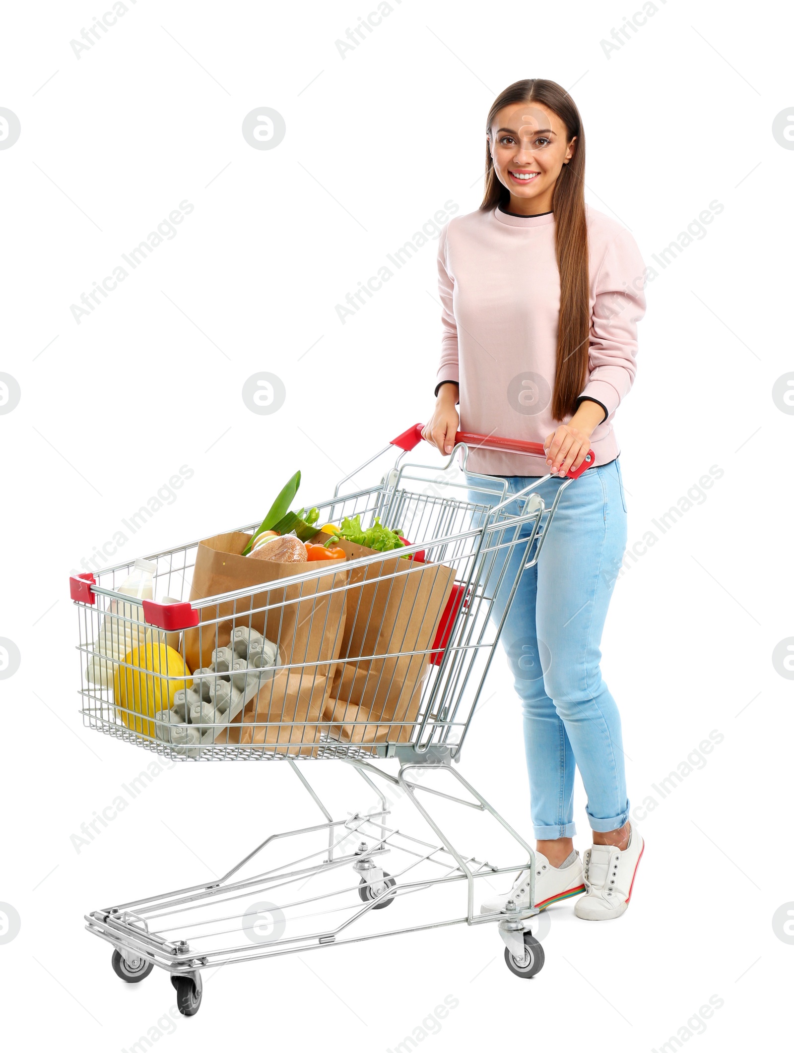 Photo of Young woman with full shopping cart on white background