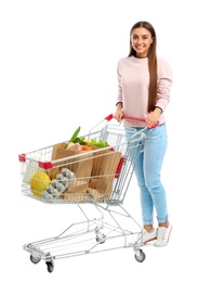 Young woman with full shopping cart on white background