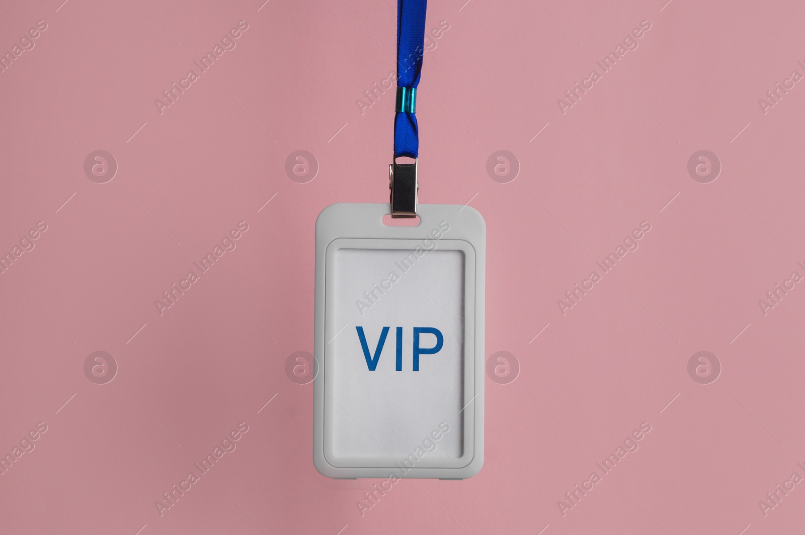 Photo of Plastic vip badge hanging on pale pink background