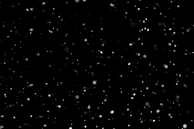 Photo of White snow falling down on black background