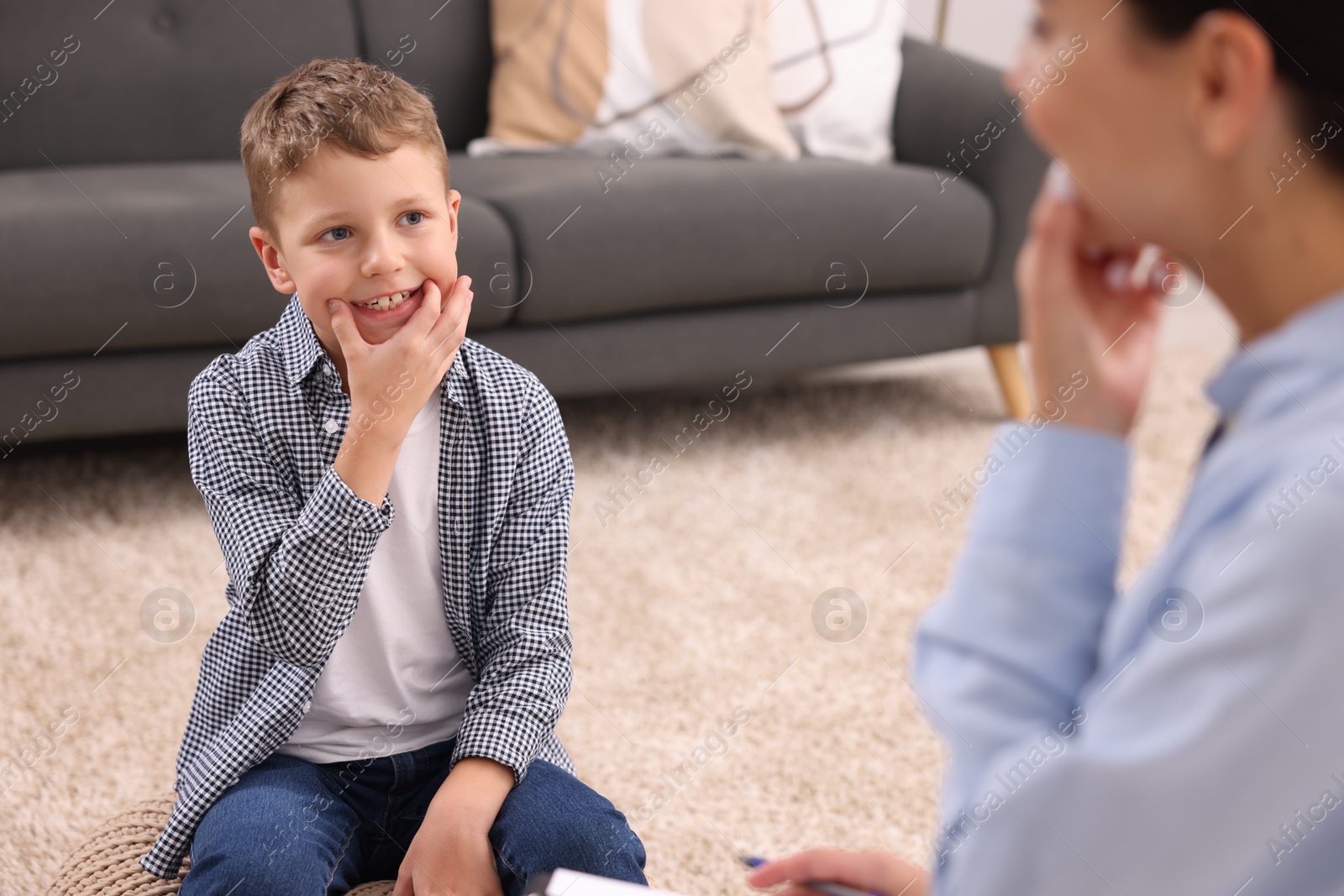 Photo of Dyslexia treatment. Speech therapist working with boy in room