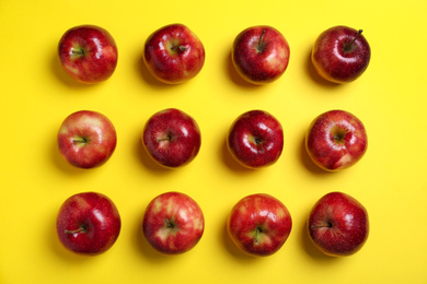 Photo of Tasty red apples on yellow background, flat lay