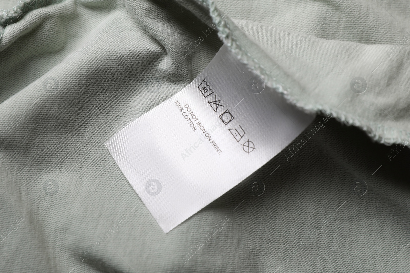 Photo of Clothing label on pale olive garment, closeup