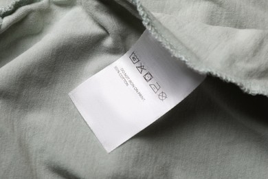 Photo of Clothing label on pale olive garment, closeup