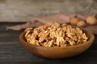 Photo of Dishware with tasty walnuts on wooden table