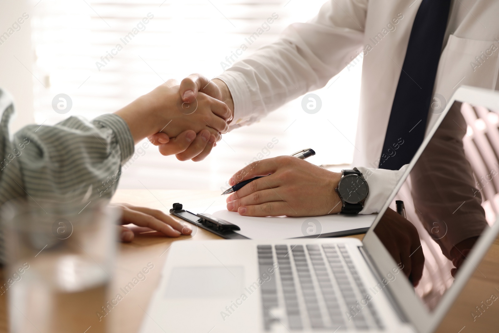 Photo of Business people shaking hands in office, closeup