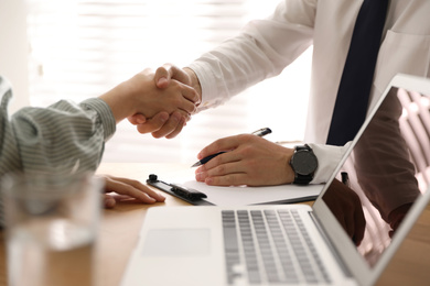 Business people shaking hands in office, closeup