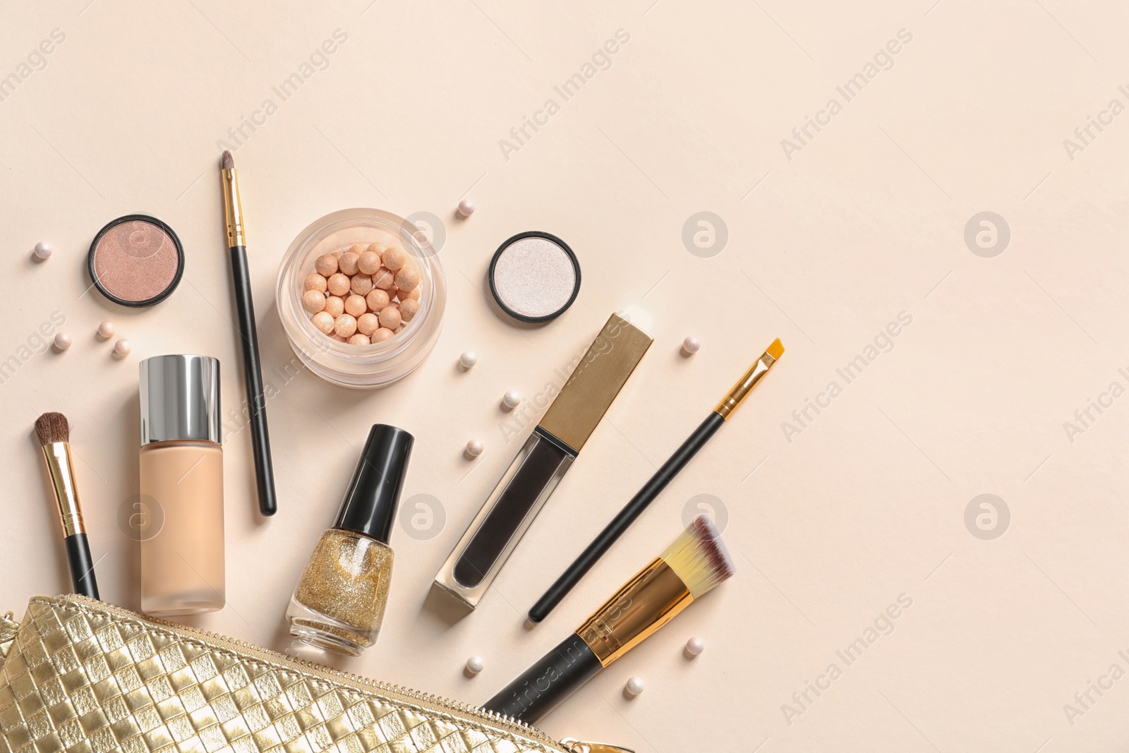 Photo of Cosmetic bag and different luxury makeup products on color background, flat lay. Space for text