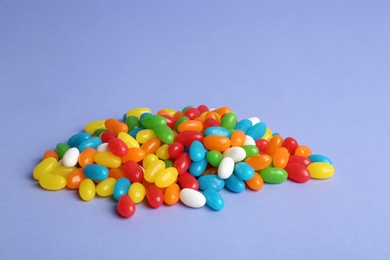 Photo of Delicious bright jelly beans on color background