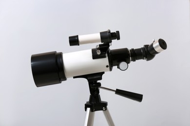 Photo of Tripod with modern telescope on light background, closeup