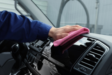 Car wash worker cleaning automobile interior, closeup