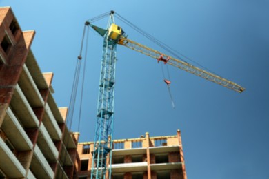 Photo of View of unfinished building and tower crane against blue sky