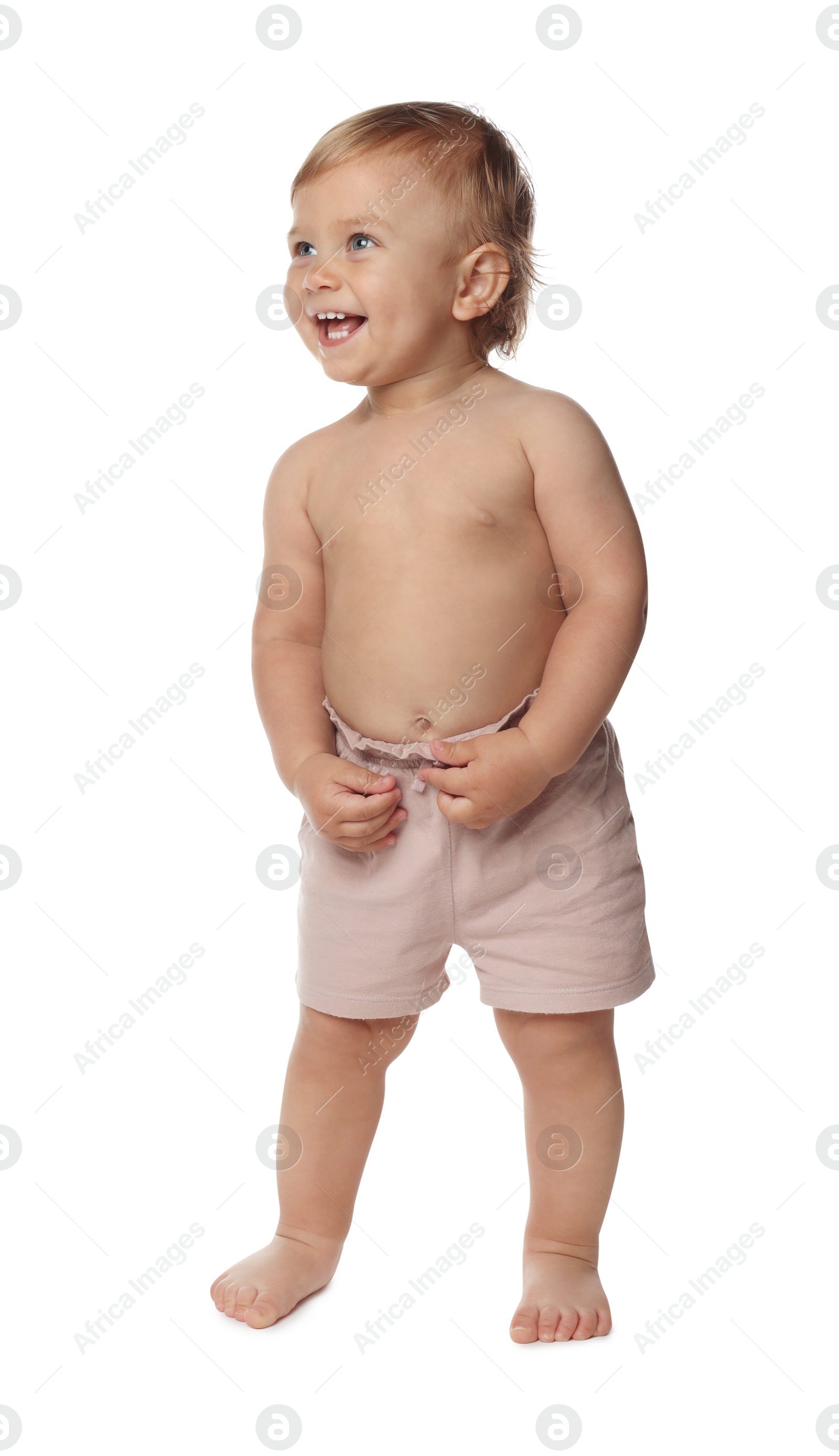 Photo of Cute baby in shorts learning to walk on white background