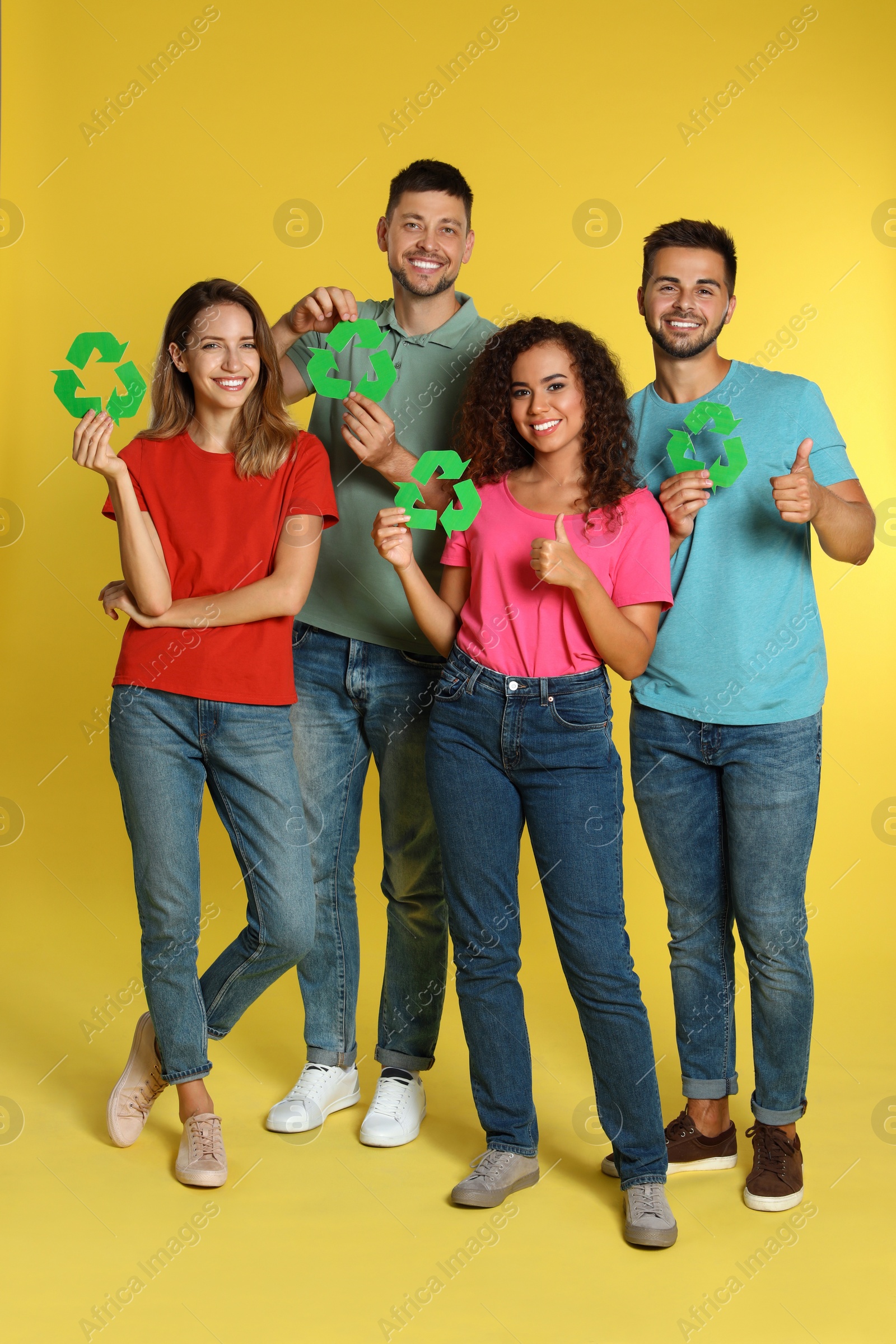 Photo of Group of people with recycling symbols on yellow background