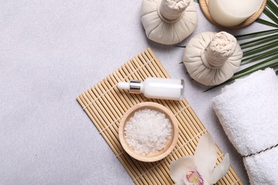 Photo of Flat lay composition with herbal massage bags, spa products and leaves on light grey table