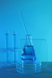 Photo of Laboratory analysis. Different glassware on table against blue background