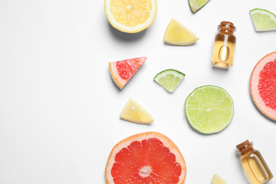 Photo of Flat lay composition with bottles of citrus essential oil on white background