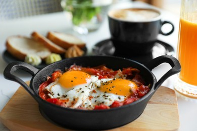 Photo of Tasty Shakshouka served on white table, closeup. Traditional Arabic dish