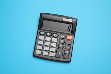 Photo of Calculator on light blue background, top view. Office equipment