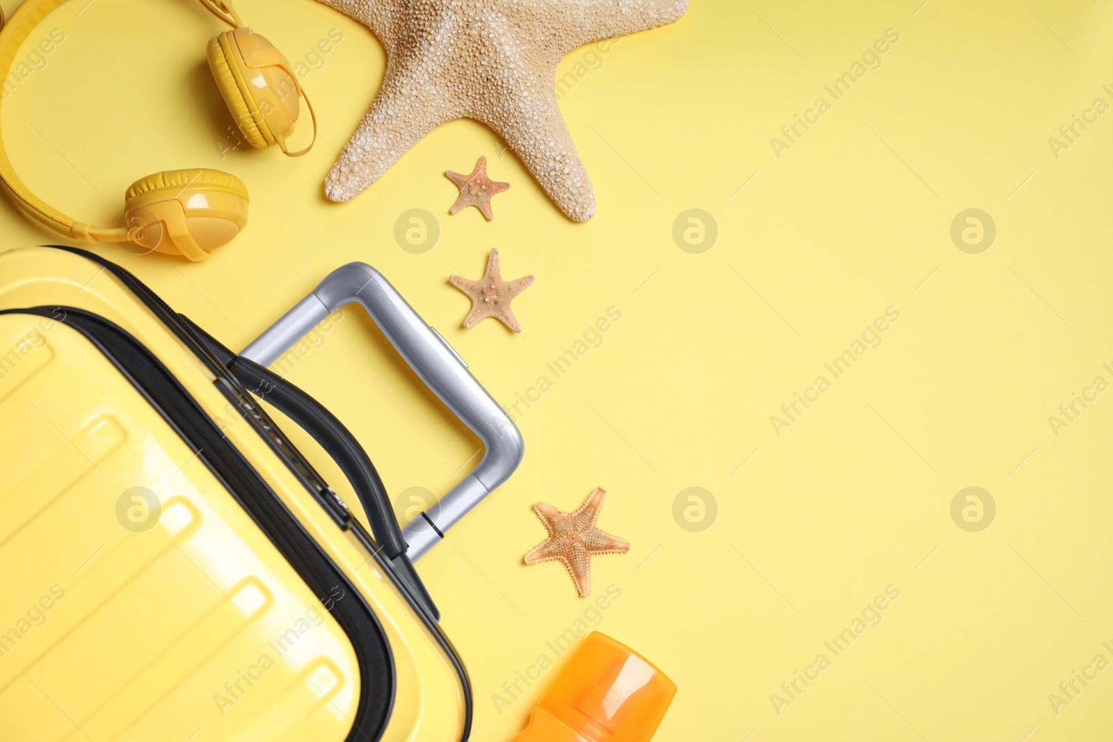 Photo of Flat lay composition with suitcase on yellow background. Space for text