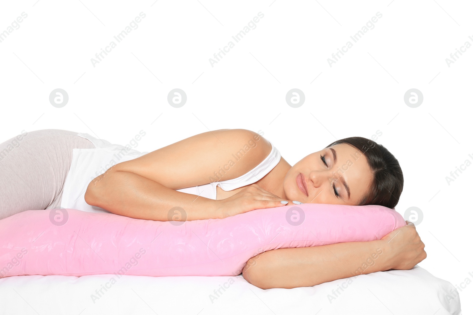 Photo of Beautiful pregnant woman sleeping with maternity pillow on bed against white background