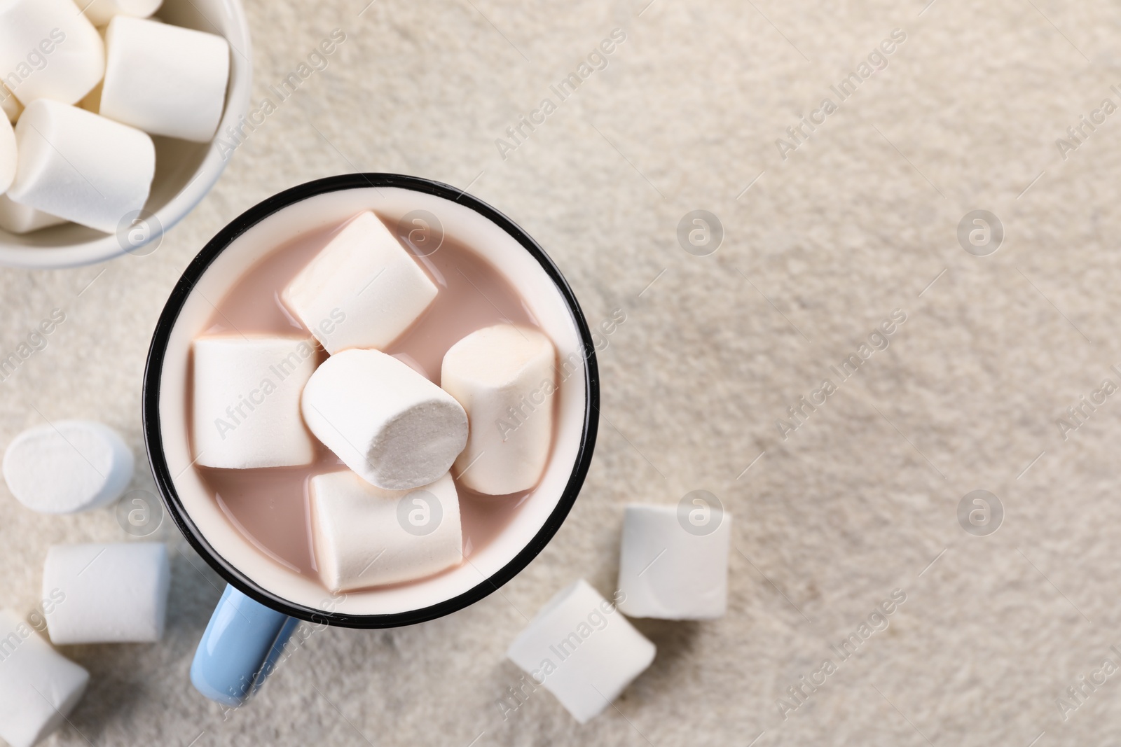 Photo of Cup of aromatic hot chocolate with marshmallows on beige table, flat lay. Space for text