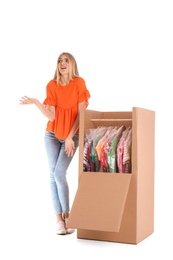 Young emotional woman near wardrobe box on white background