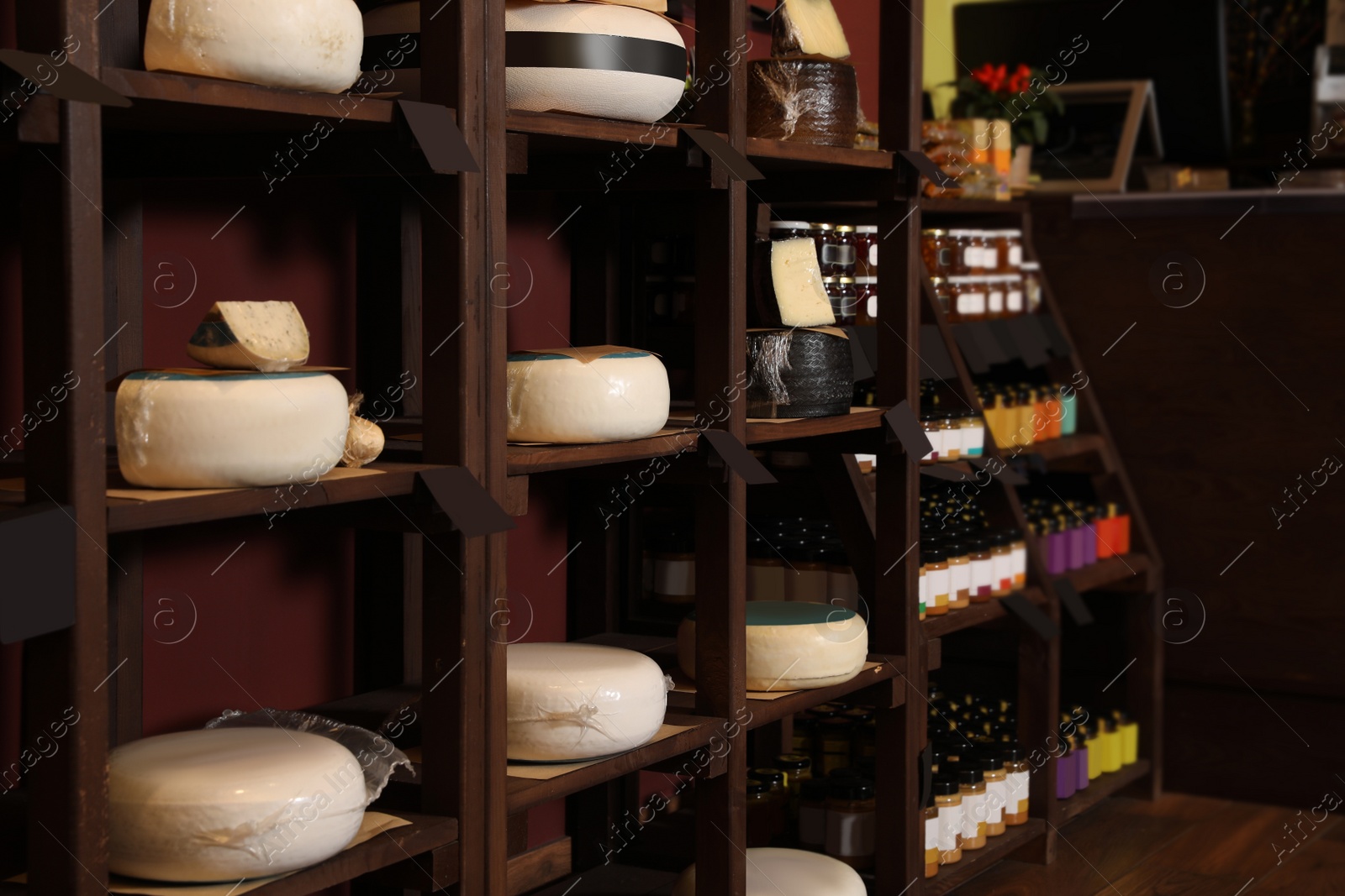 Photo of Different types of delicious cheeses on rack in store