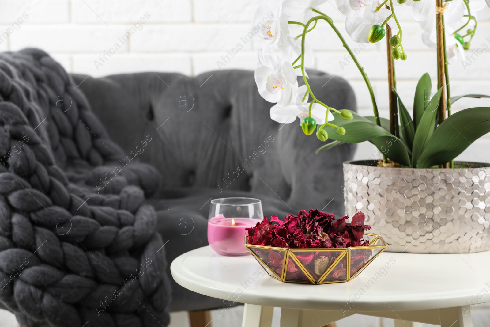 Photo of Aromatic potpourri of dried flowers in bowl, beautiful houseplant and candle on white table indoors. Space for text