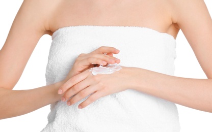 Photo of Young woman applying hand cream on white background, closeup