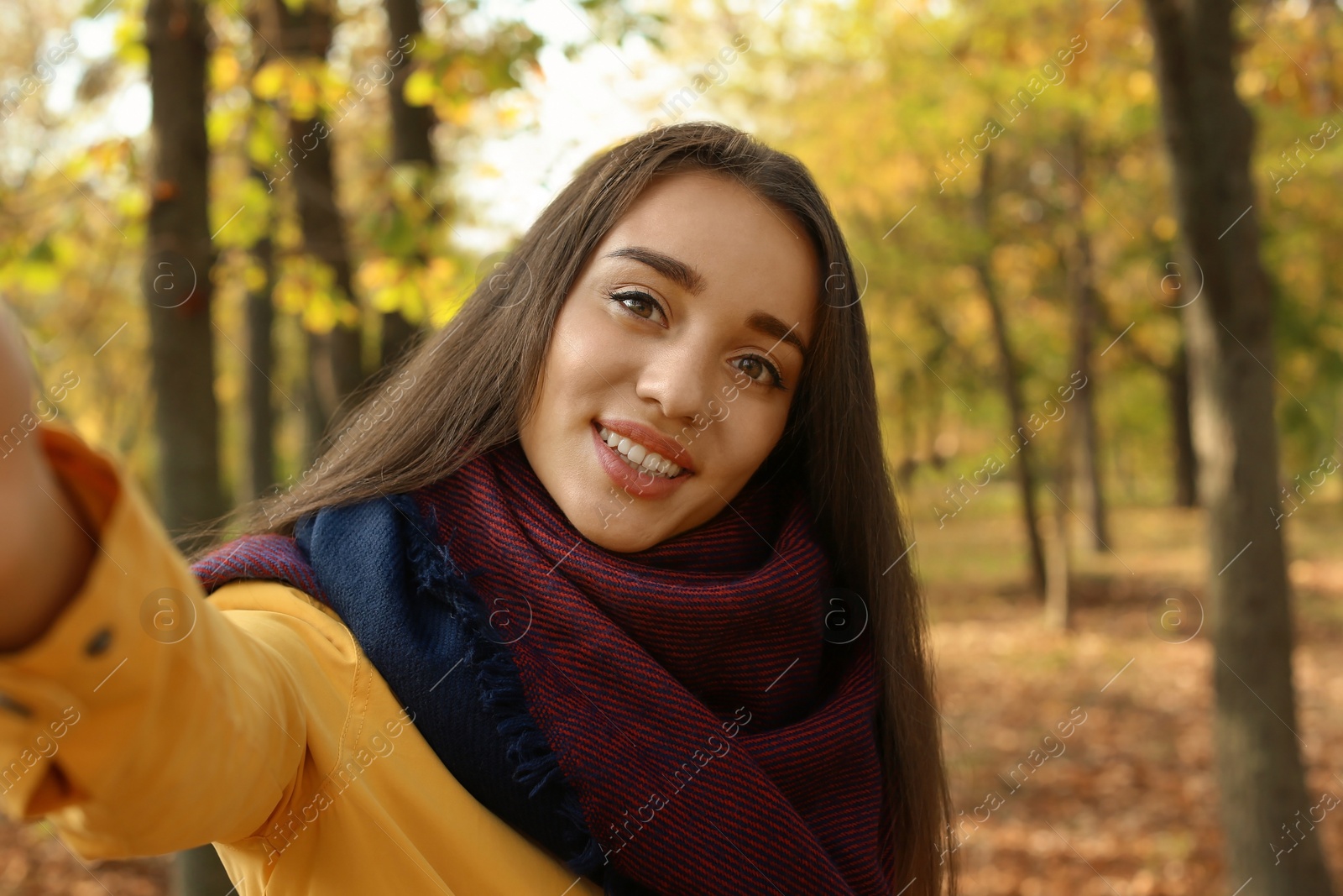 Photo of Young beautiful woman taking selfie in park. Autumn walk