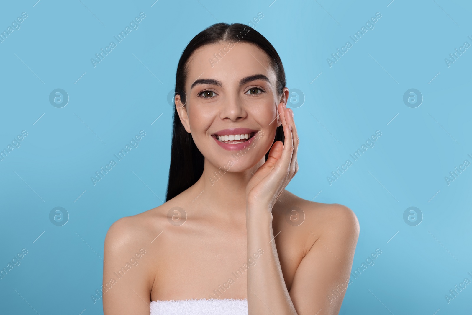 Photo of Portrait of attractive young woman on light blue background. Spa treatment