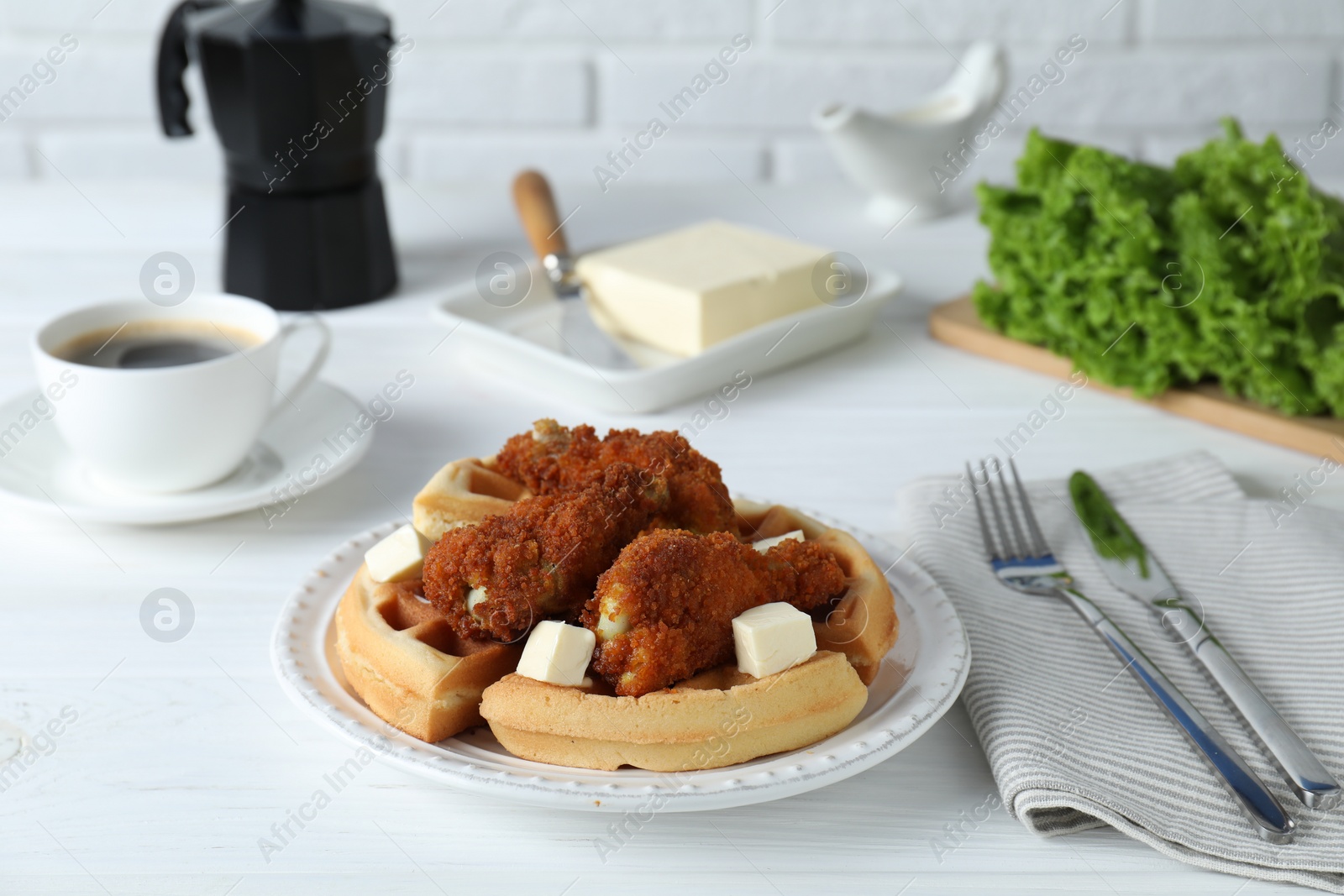 Photo of Delicious Belgium waffles served with fried chicken and butter on white table