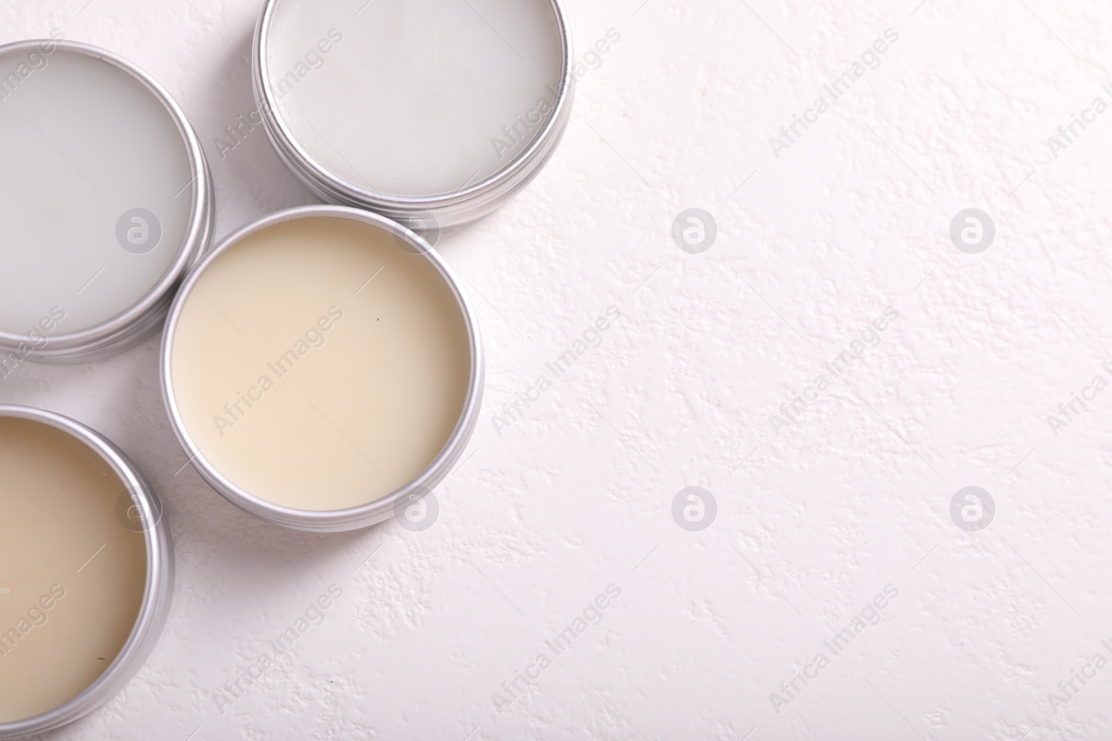 Photo of Different lip balms on white table, flat lay. Space for text