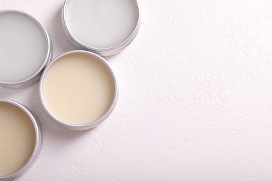 Different lip balms on white table, flat lay. Space for text