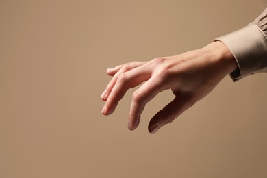 Photo of Woman holding something in hand on beige background, closeup